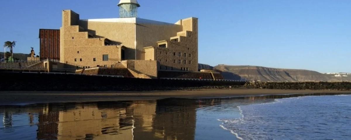 El Auditorio Alfredo Kraus reflejado sobre la arena mojada de la playa de Las Canteras, en Las Palmas de Gran Canaria